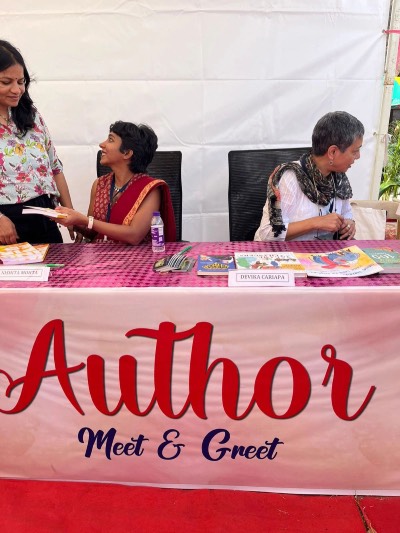 Nishita Mohta at an author meet and greet, signing copies of Inspired